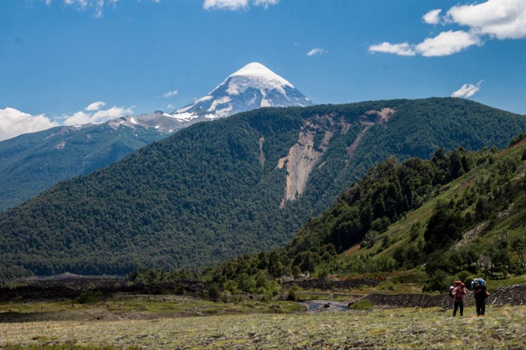 Skyline view in Lanin National Park in Argentin with wooded hills and the snow-capped cone of Lanin volcano on the horizon