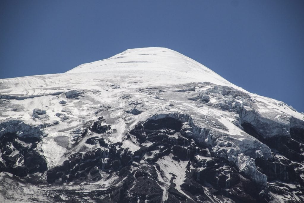 The view up to the hanging glaciers and snow-capped peak of Lanine Volcano in Argentin