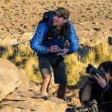 Danny Middleton from Swoop Patagonia crouching down with a camera.