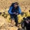 Danny Middleton from Swoop Patagonia crouching down with a camera.