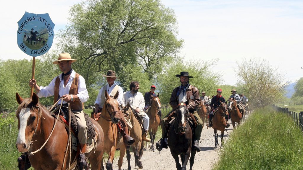 A line of gauchos on horses in Chubut, Argentina.